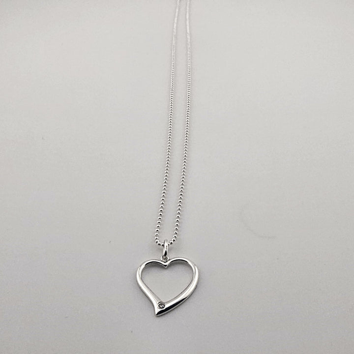 Sterling silver open heart pendant necklace with gemstone accent.