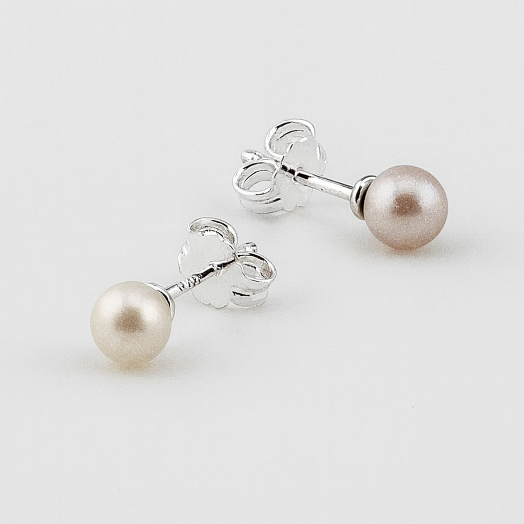 Sterling silver pearl stud earrings with butterfly backs.