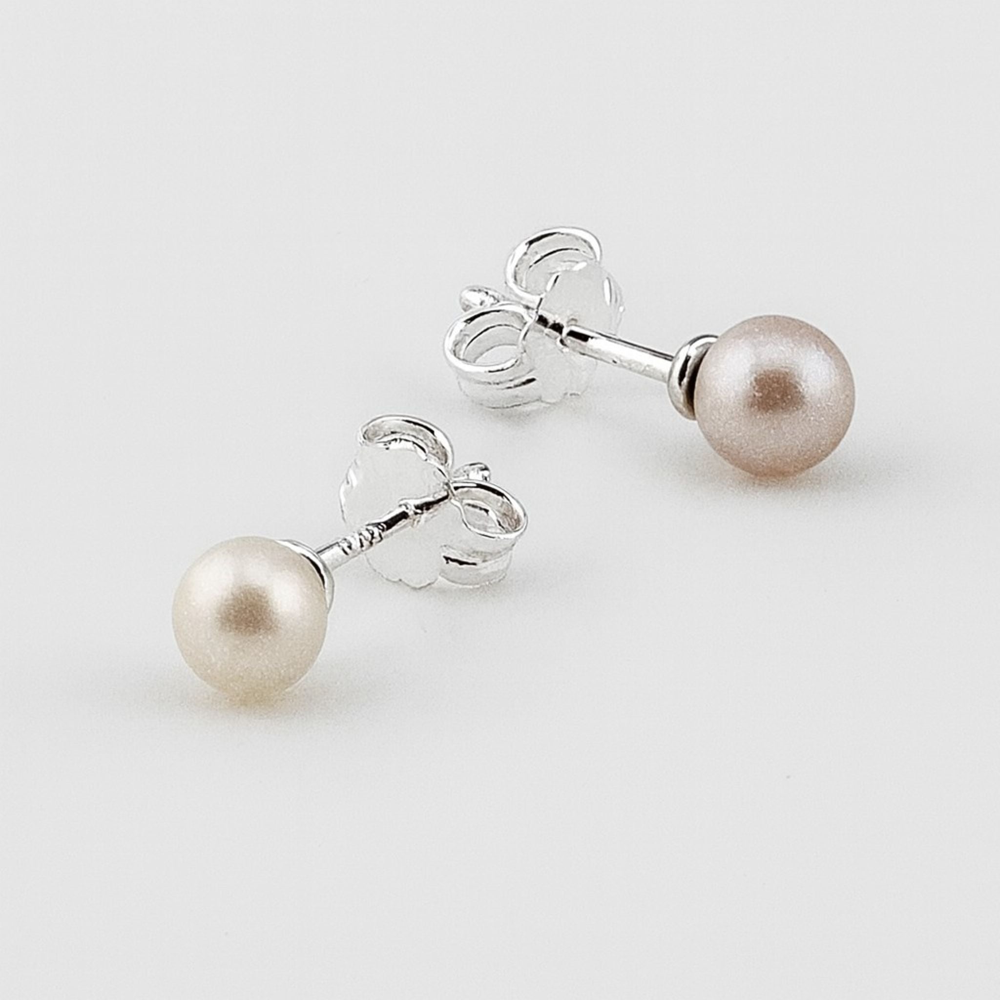 Sterling silver pearl stud earrings with butterfly backs.