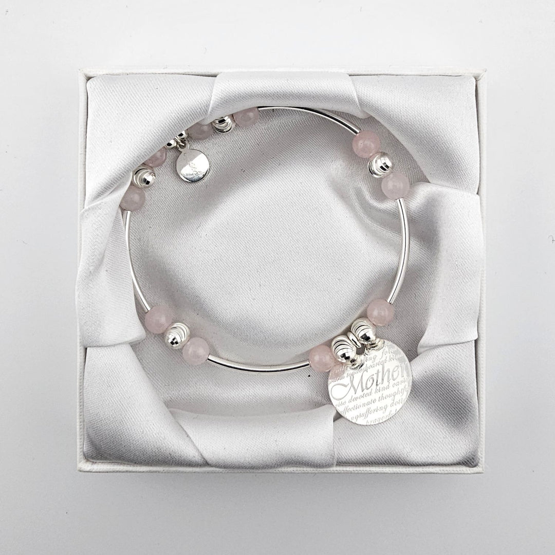 Handmade sterling silver Mother bracelet resting on satin cushion.