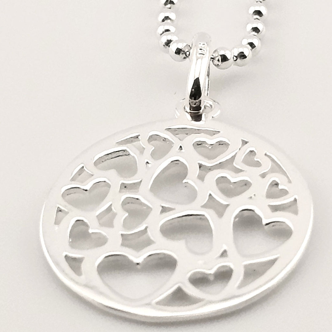 Sterling silver round pendant necklace with multiple cut-out hearts design.