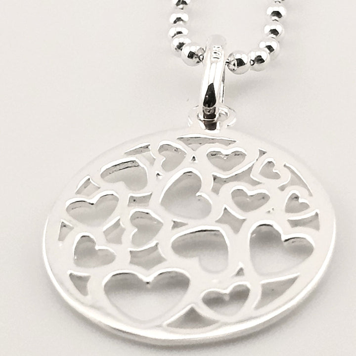 Sterling silver round pendant necklace with multiple cut-out hearts design.