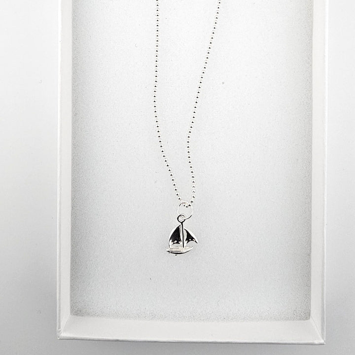 Sterling silver sail boat necklace presented in gift box.