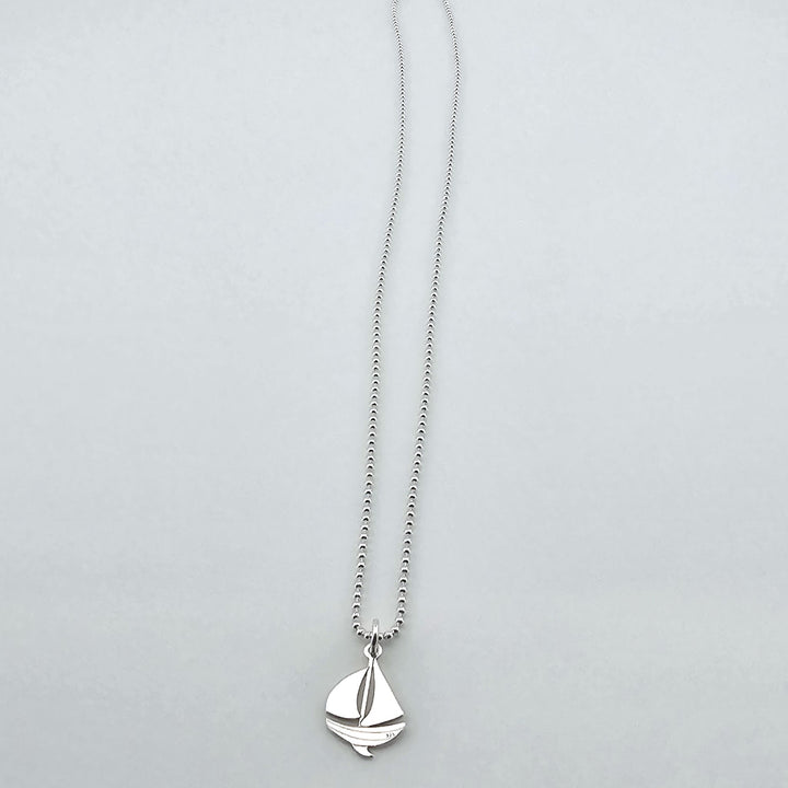 Unisex sterling silver nautical sailboat necklace, polished finish.