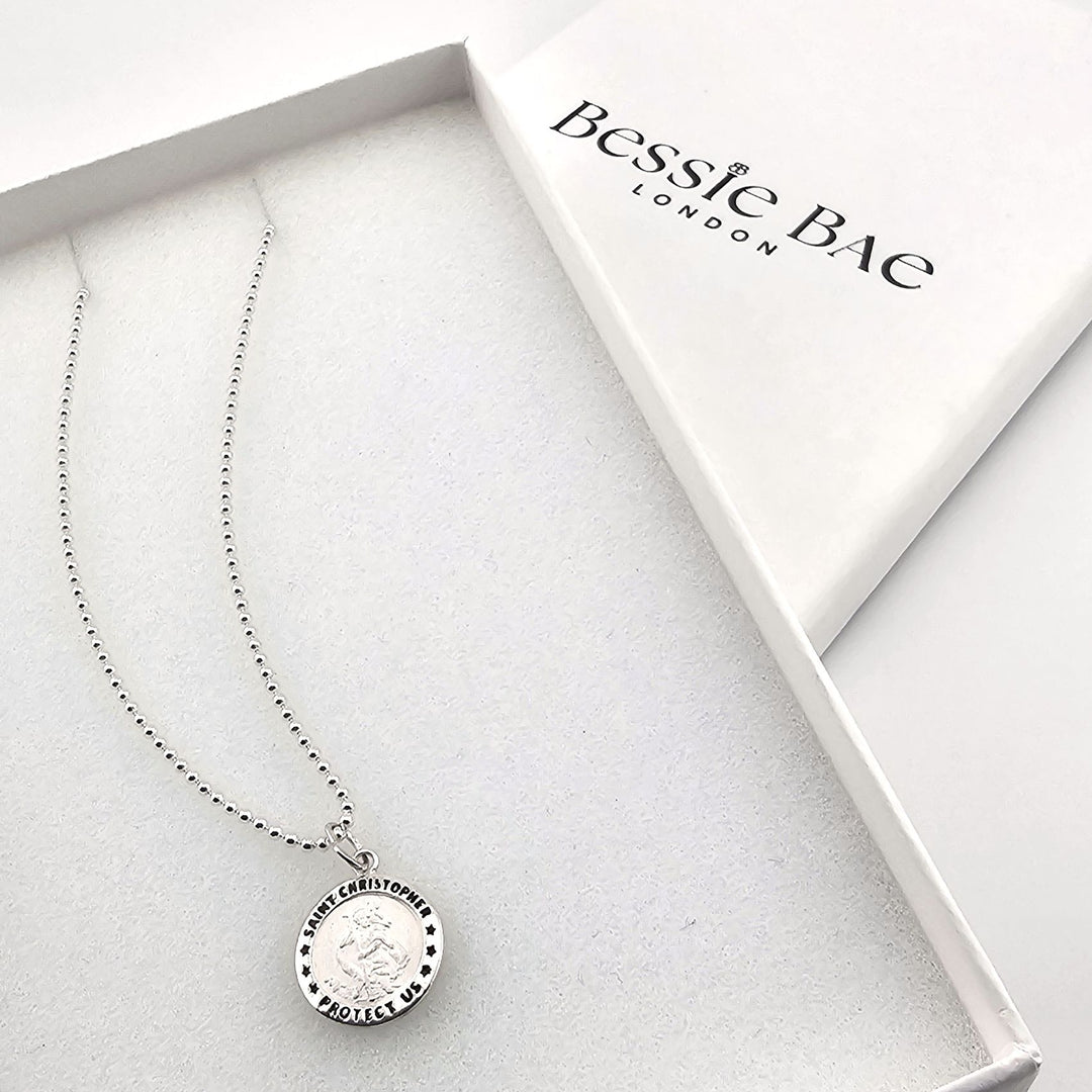 Close-up of sterling silver Saint Christopher necklace, protection travel gift.