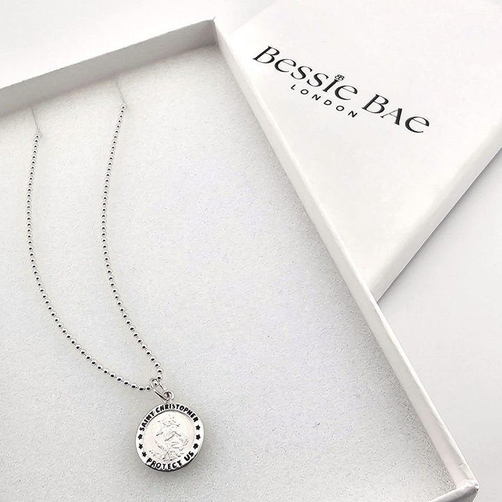 Close-up of sterling silver Saint Christopher necklace, protection travel gift.