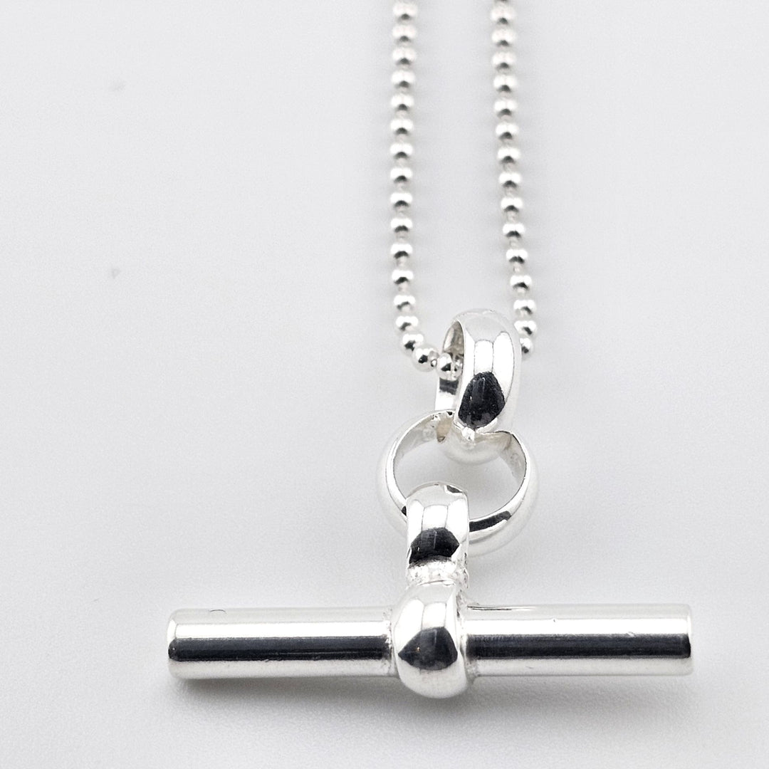 Sterling silver T-bar pendant necklace on ball chain, minimalist design.