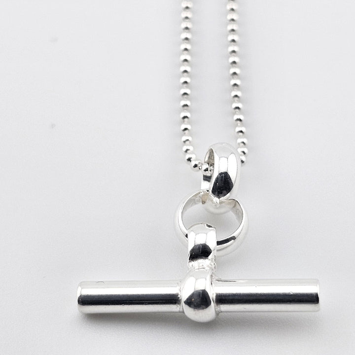 Sterling silver T-bar pendant necklace on ball chain, minimalist design.