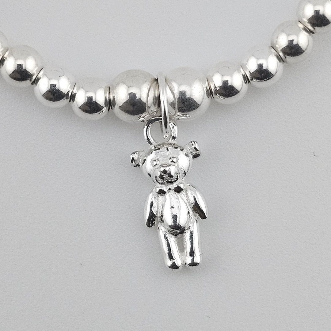 Close-up of Sterling Silver Teddy Bear charm on gemstone and pearl bracelet.
