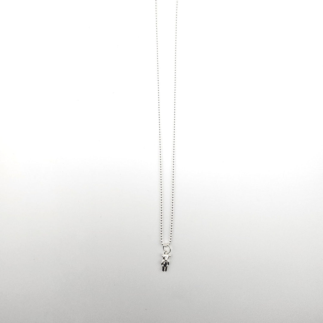 Sterling silver teddy bear pendant necklace on a fine silver ball chain against a white background.