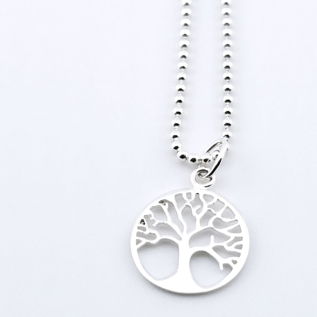 Close-up of sterling silver Tree of Life necklace with cut-out design.