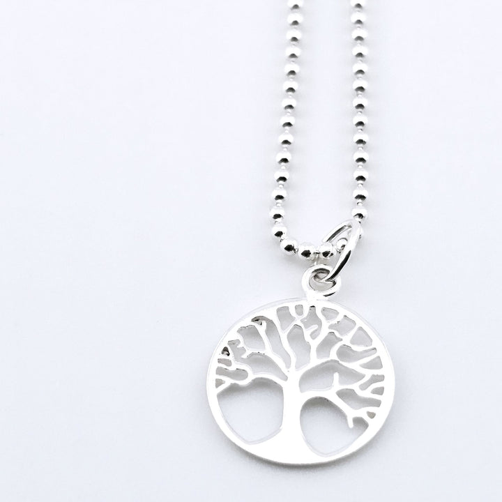 Close-up of sterling silver Tree of Life necklace with cut-out design.