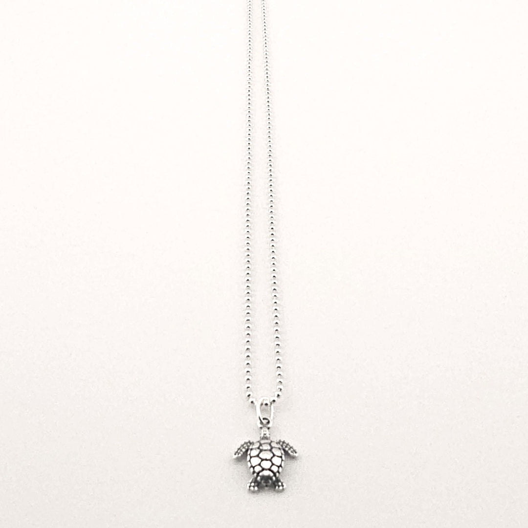 Sterling silver turtle pendant necklace on fine chain.