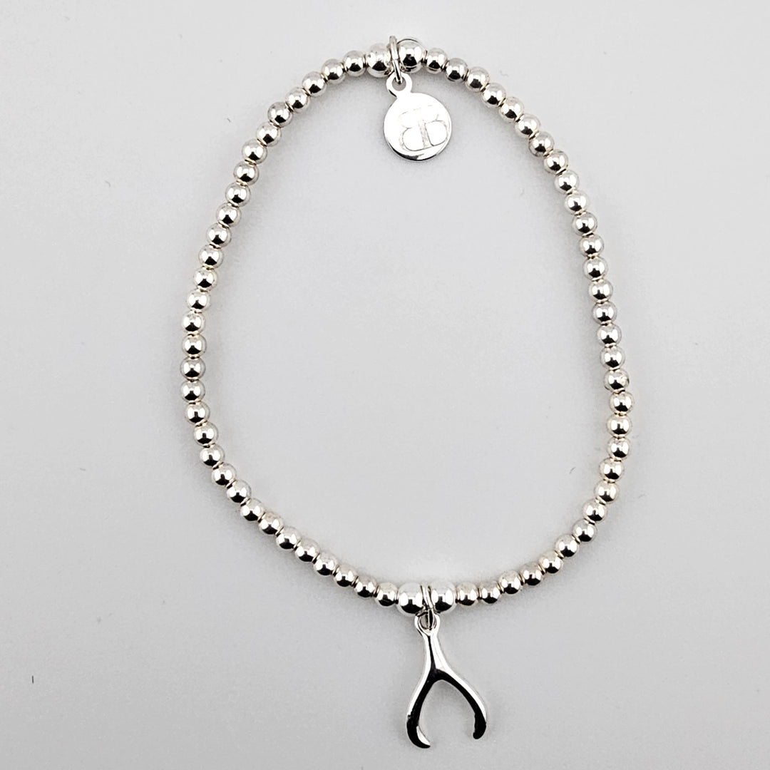 Sterling silver beaded bracelet with small wishbone charm.