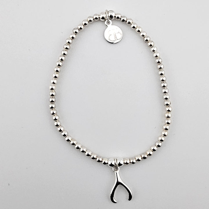 Sterling silver beaded bracelet with small wishbone charm.