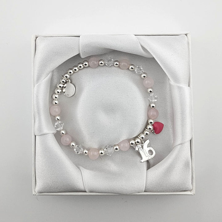 Bessie Bae packaging with Sterling Silver 16 charm bracelet presented in white satin box.