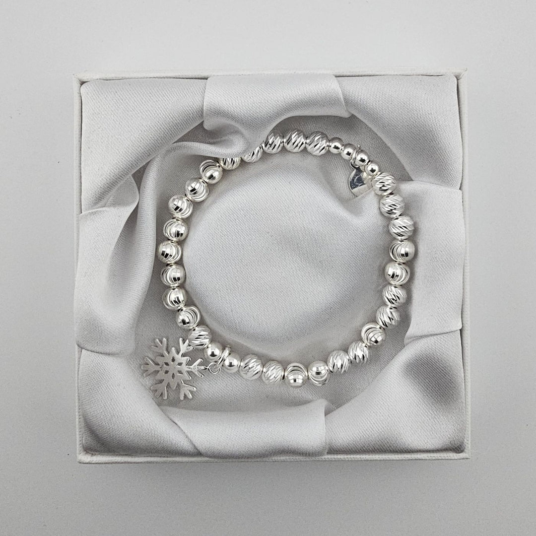 Top view of sterling silver beaded snowflake charm bracelet in gift box.